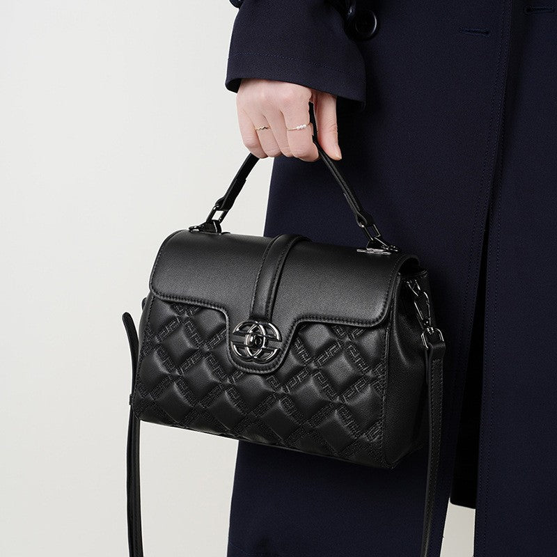 The black top handle flap bag can be handheld or carried crossbody.