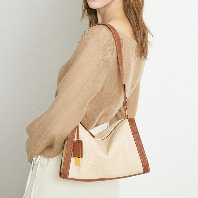 The two - tone brown beige boston hobo shoulder bag is in a pillow shape.