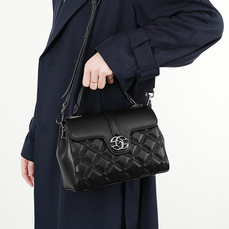 The black crossbody bag, which has a top handle, a flap design, an embossed pattern and an adjustable sling strap, can be handheld or carried over the shoulder or crossbody.