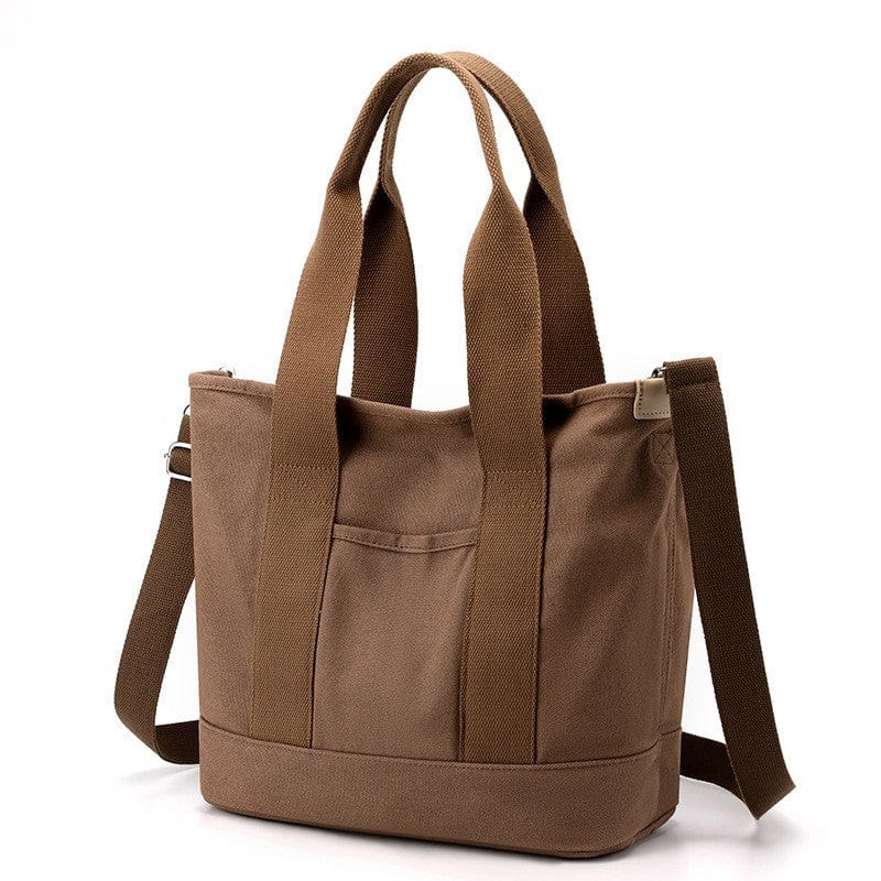 The large brown tote bag with zipper is made of canvas material, being able to be carried on the shoulder or crossbody.