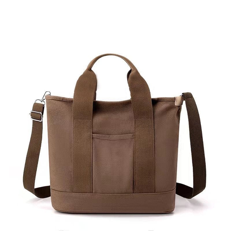 The small brown tote bag with zipper is made of canvas material, being able to be carried on the shoulder or crossbody.