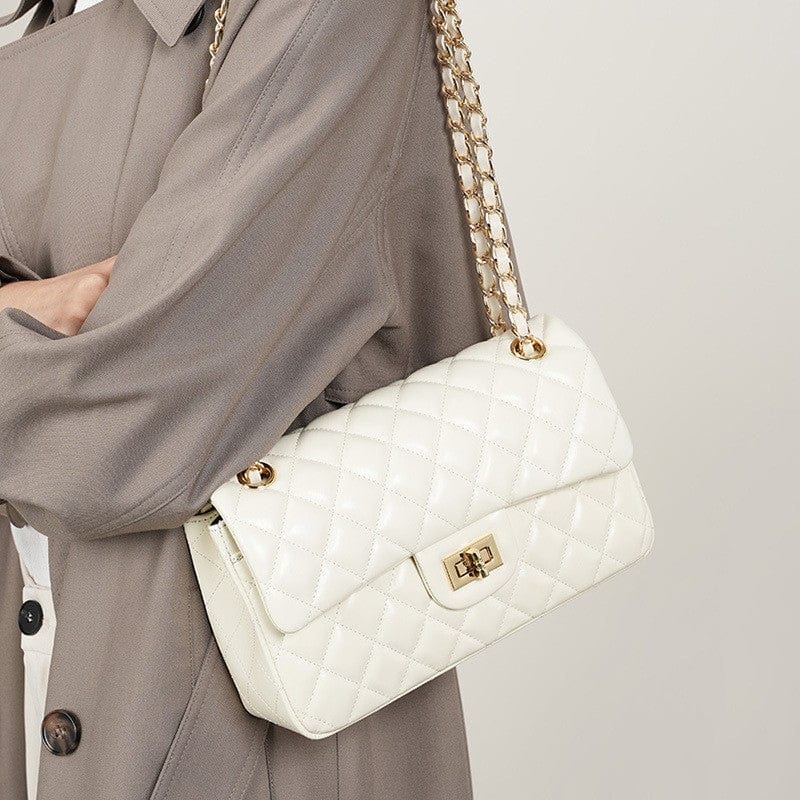 This white shoulder sling crossbody bag has a classic flap design, with a diamond - quilted pattern. 